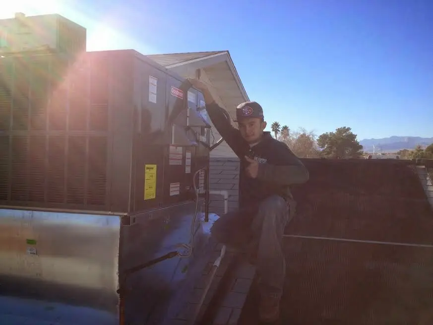 HVAC technician performing HVAC Inspection on a rooftop unit in Selma